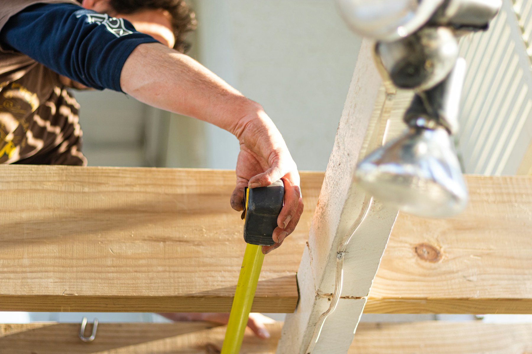 Builder measuring timber at a worksite